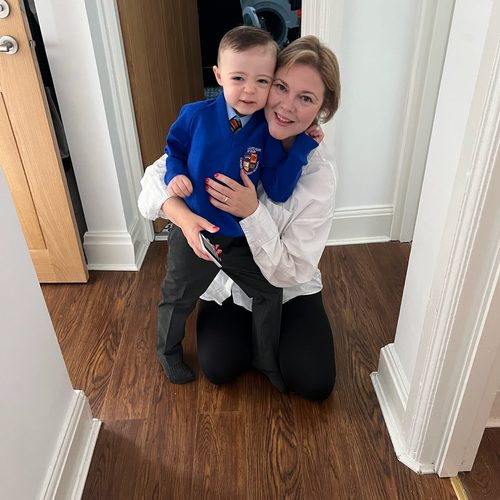 Freddie in his school uniform, hugging his mum